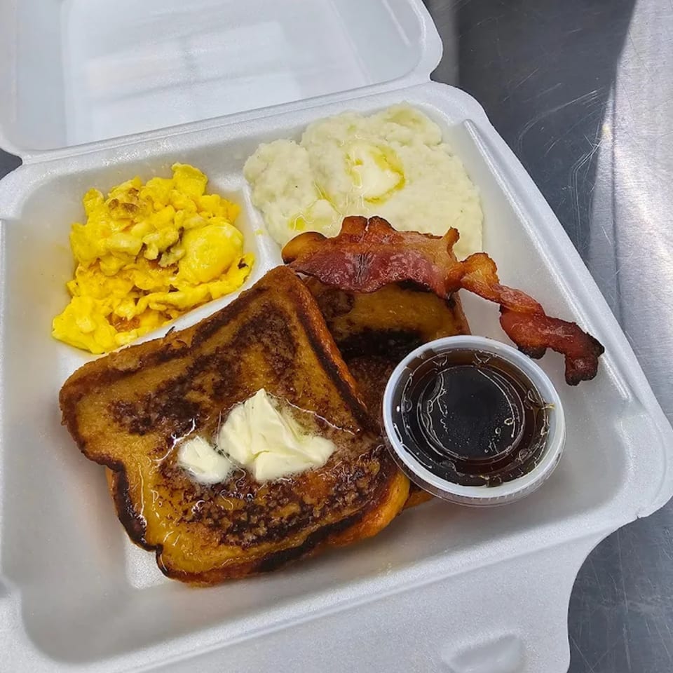 Jaguar's Spot breakfast with French toast, scrambled eggs, mashed potatoes, bacon, and syrup.