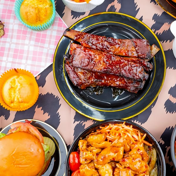 Jaguar's Spot BBQ ribs, burger, and chicken dish on a leopard print tablecloth.