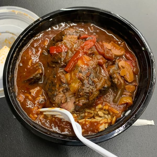 A close-up of a hearty American dish from Jaguar's Spot, featuring meat, rice, and vegetables in a rich sauce.