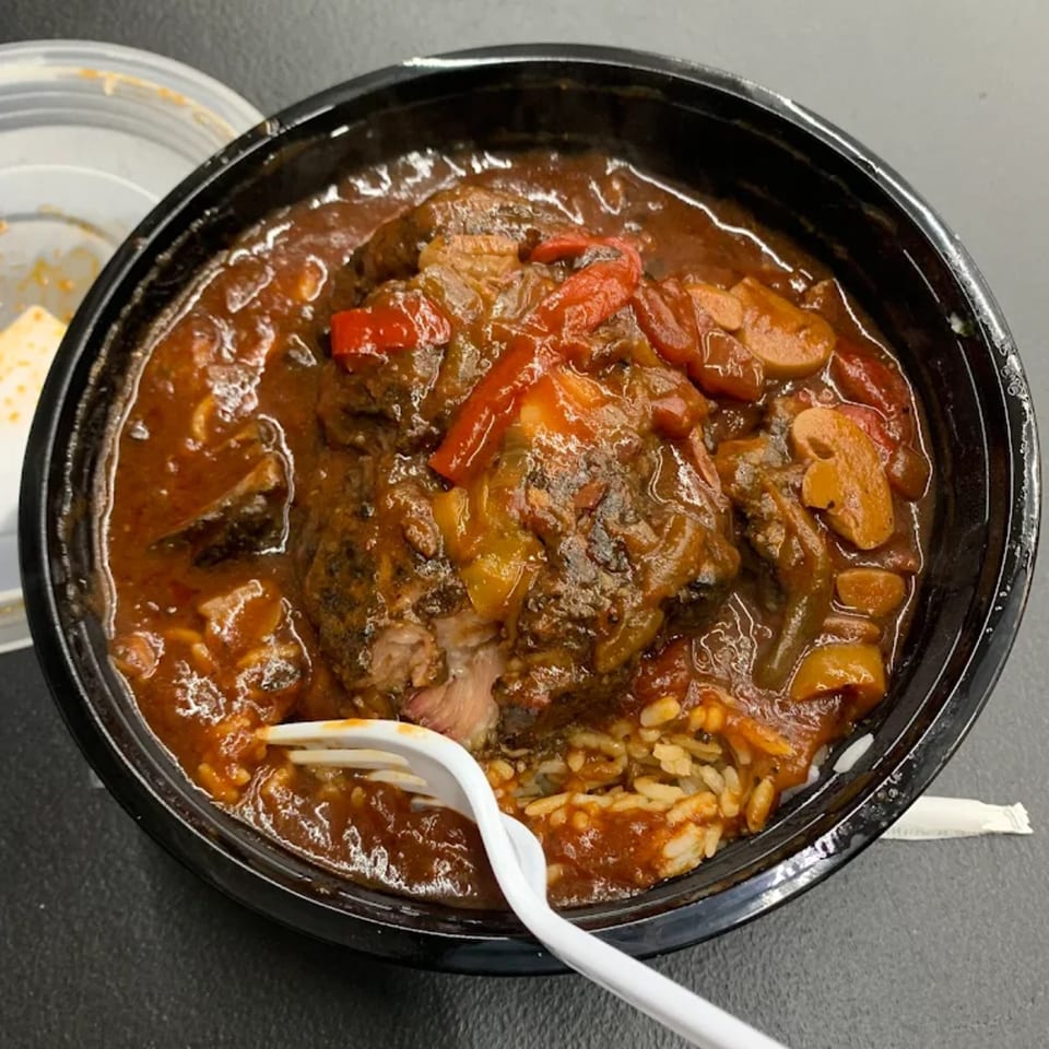 A close-up of a hearty American dish from Jaguar's Spot, featuring meat, rice, and vegetables in a rich sauce.