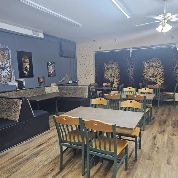 Jaguar's Spot dining room with leopard print booths, tables, chairs, and jaguar artwork on the walls.